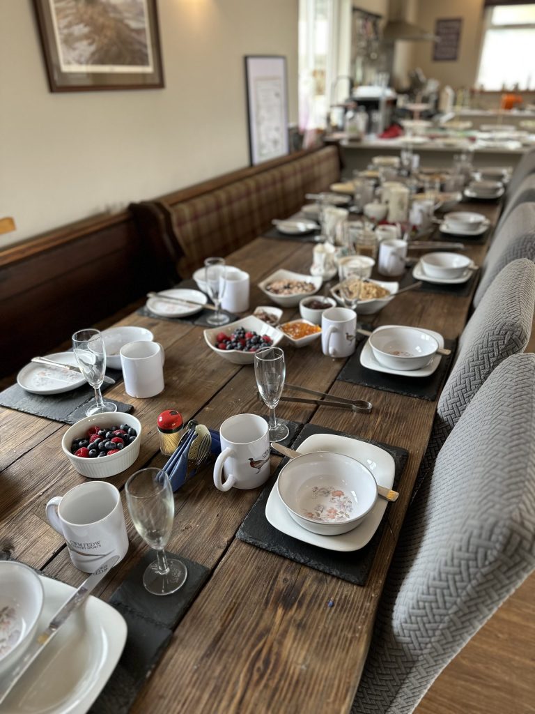 Table prepared for breakfast with food being served